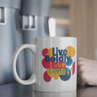 Stylish 11 oz mug with 'Live Boldly, Love Deeply' in vibrant colors and curvy shapes on a kitchen counter.
