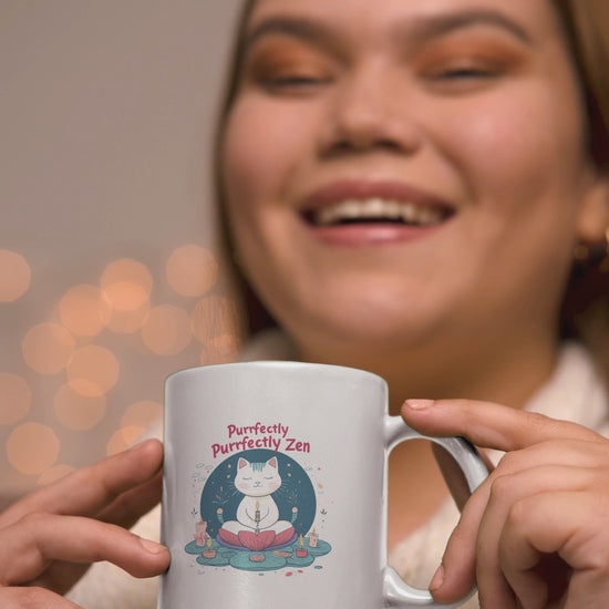 Smiling person holding a cute cat yoga mug that says 'Purrfectly Zen', ideal for cat lovers and coffee enthusiasts.